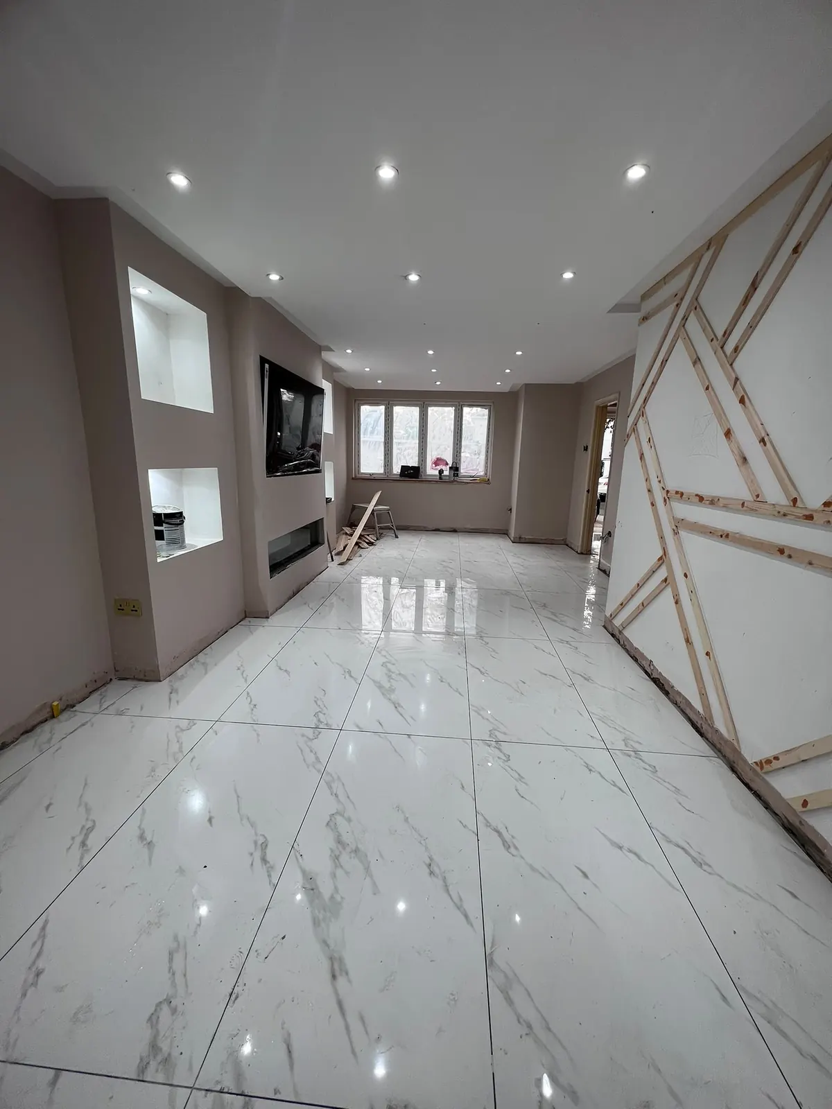 Finished open-plan lounge with marble-effect porcelain flooring and a built-in media wall, Upminster